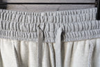Elastic waistband with drawstring cord on light gray pants