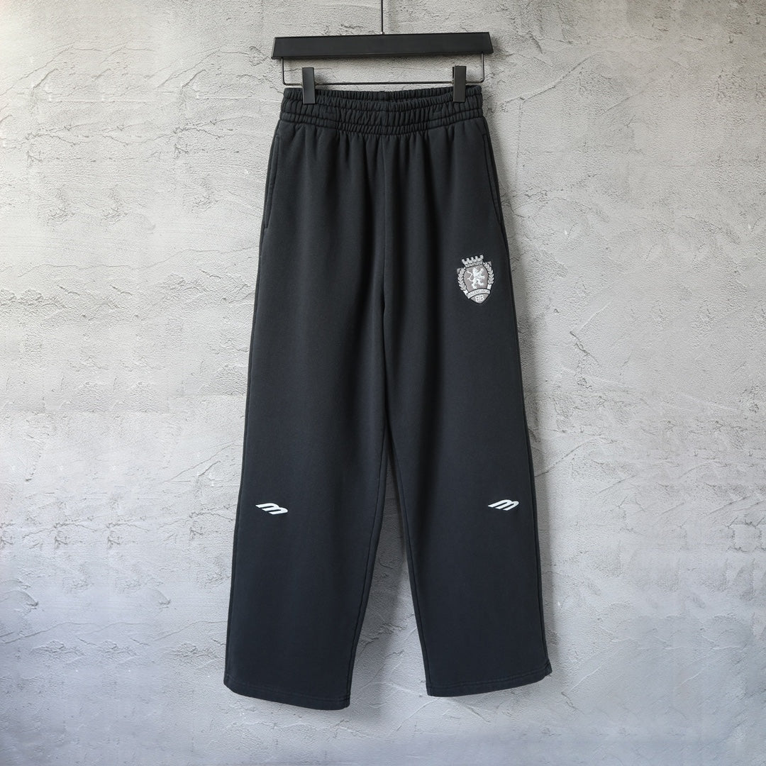 Black wide-leg pants with elastic waistband and small crest logo on left thigh