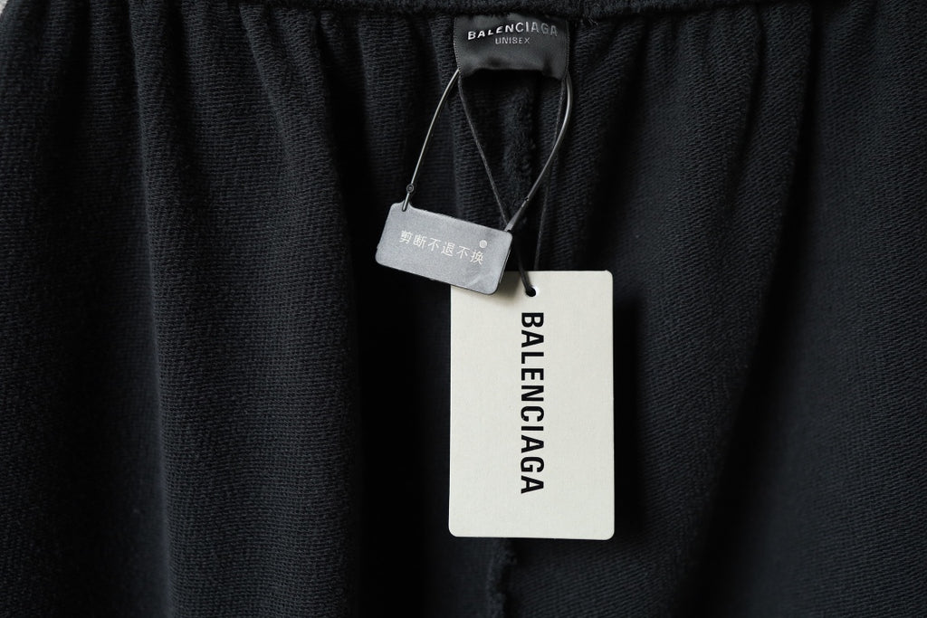 Black pants with hanging Balenciaga tags attached at waistband