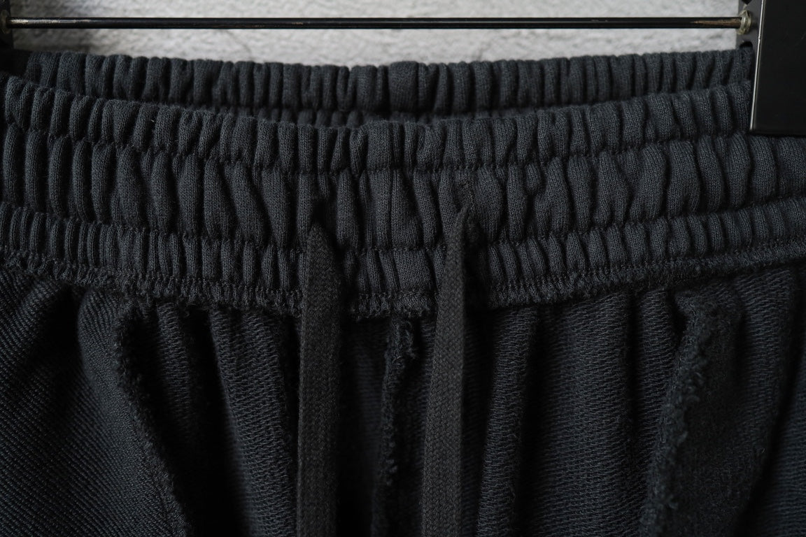 Dark pants waistband with gathered elastic and stitched seams at the top