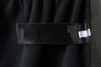 Black fabric pants with care label tag on side seam