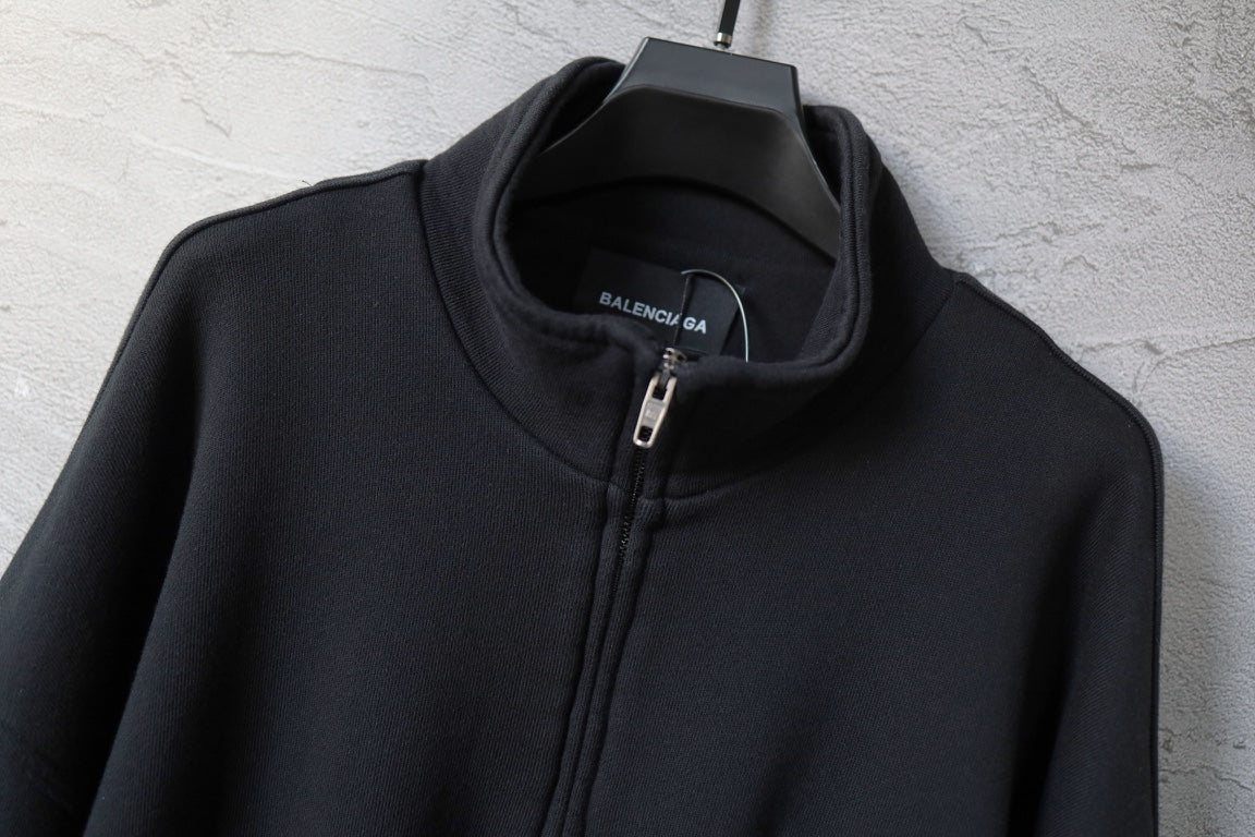 Zip-up jacket neckline with front zipper and collar, dark fabric with small internal label.