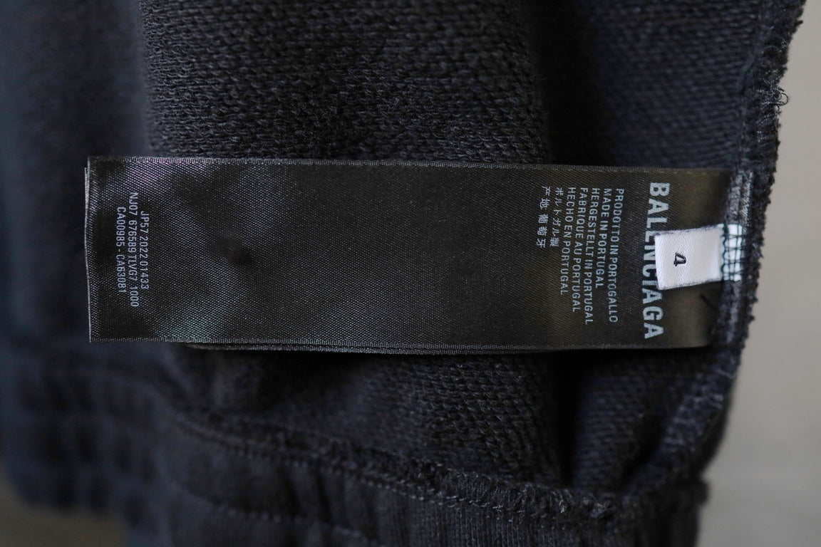 Zip-up jacket inner label and size tag on dark fabric.