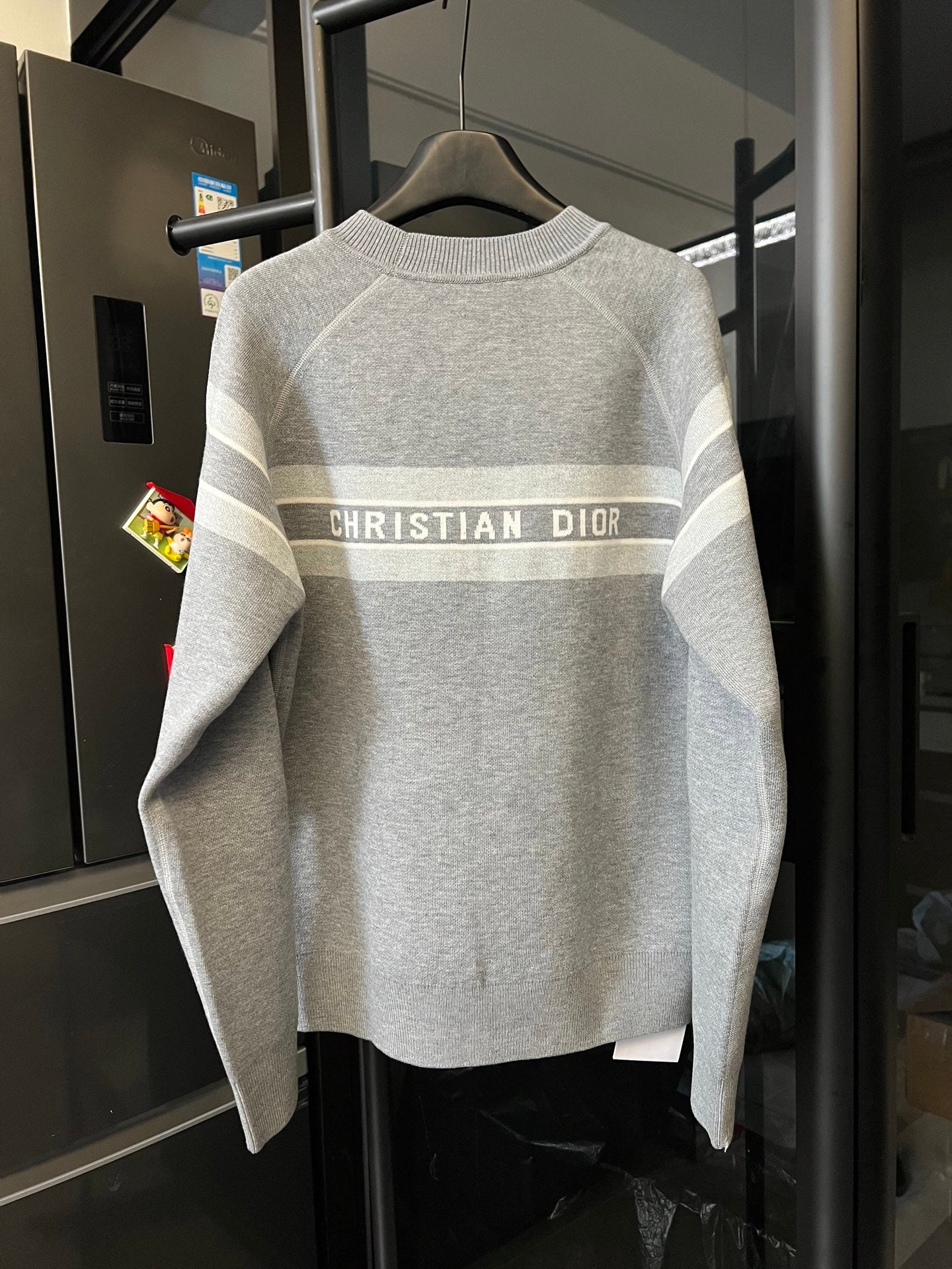 Light gray knit sweater with centered “CHRISTIAN DIOR” stripe across back