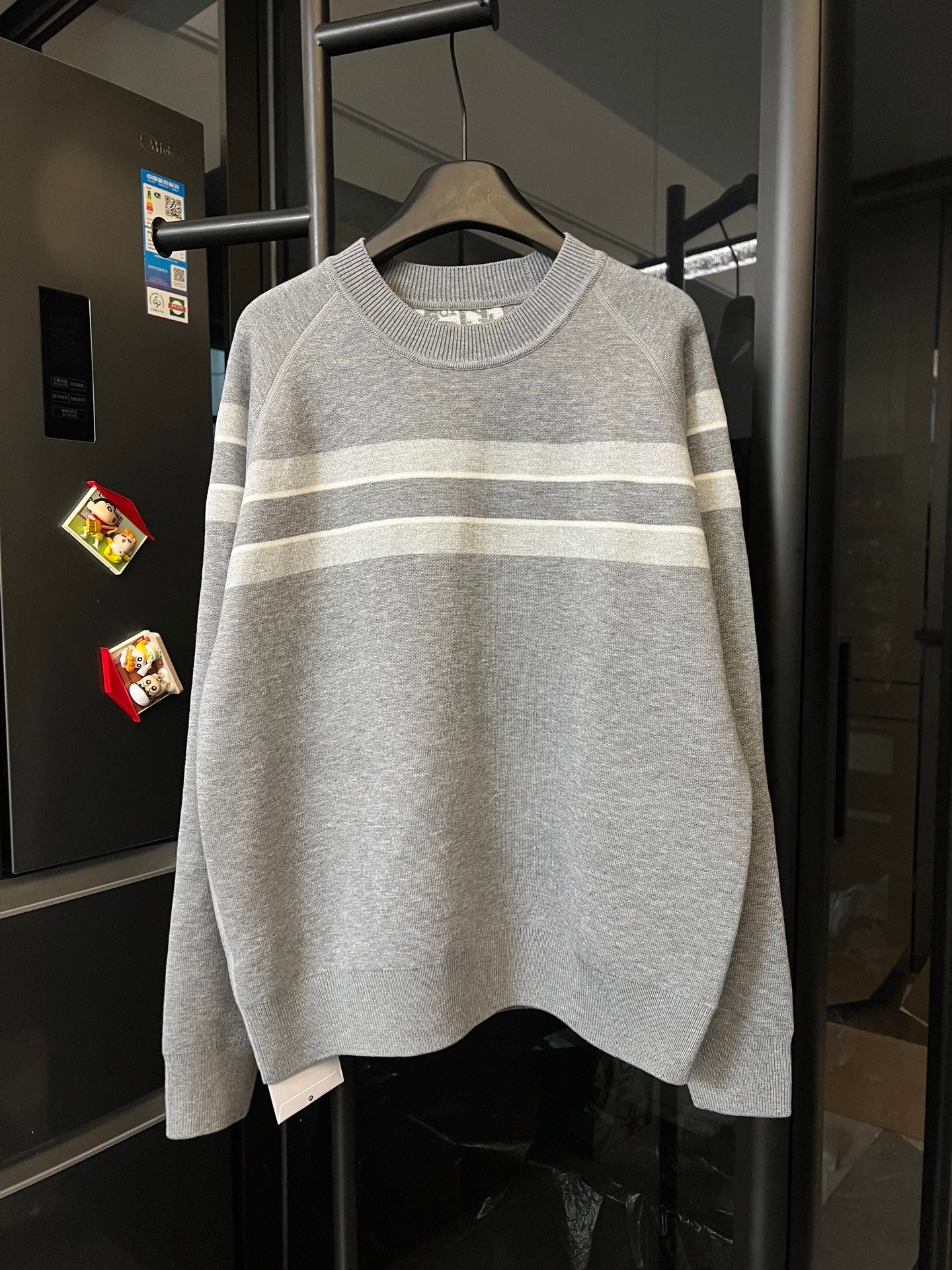 Light gray knit sweater with two-tone horizontal stripes at chest and hem