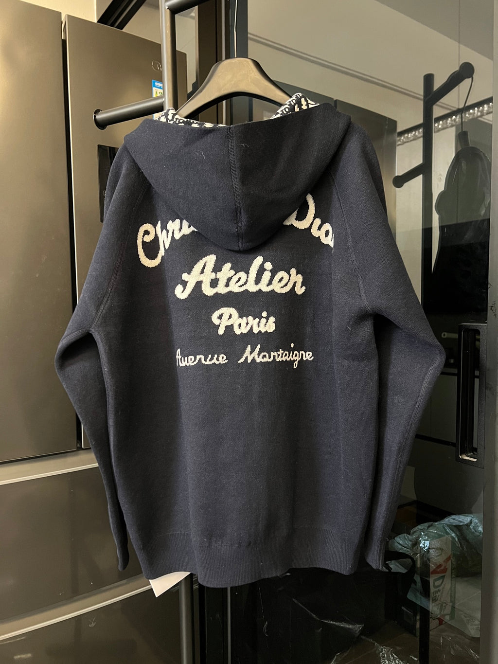 Dior long zip hoodie back view in dark gray with large printed text on hood