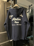 Dior long zip hoodie back view in dark gray with large printed text on hood