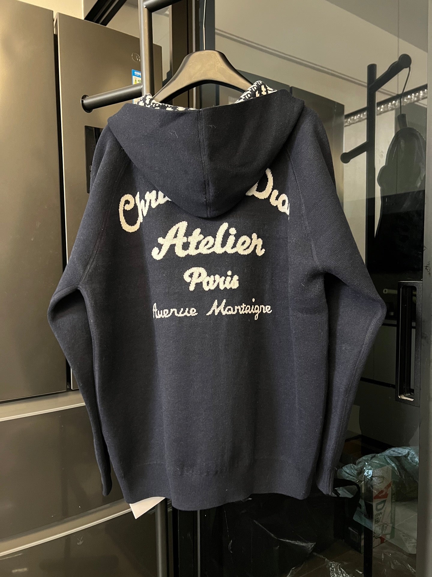 Dior long zip hoodie back view in dark gray with large printed text on hood