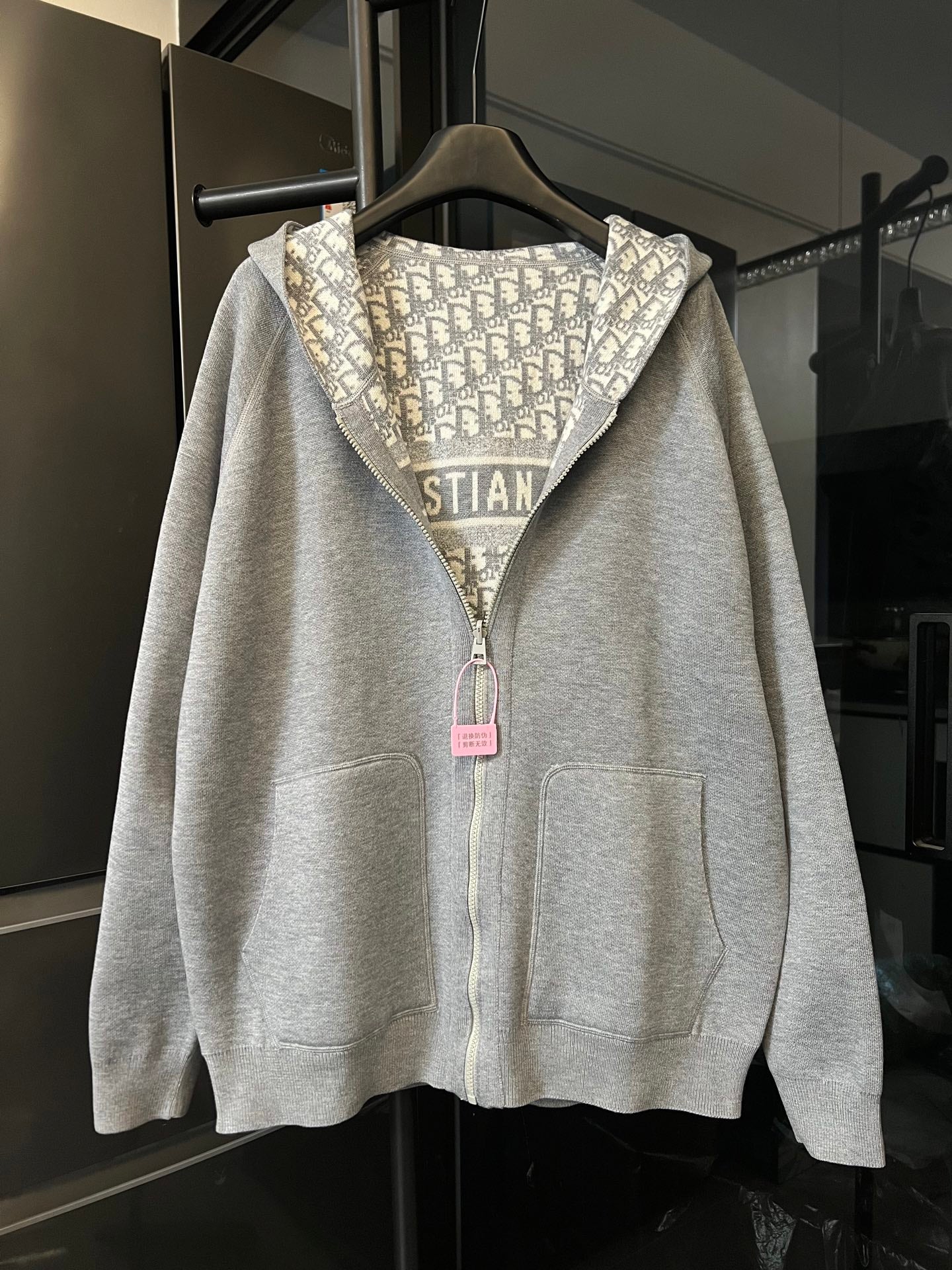 Zip-up hoodie with hood and light gray body, featuring Dior monogram hood lining