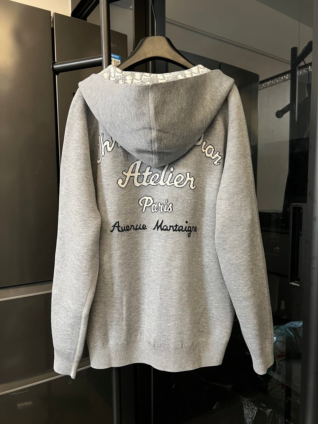 Zip-up hoodie back view with “Atelier Paris” logo text and hood