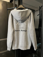Zip-up hoodie back view with “Atelier Paris” logo text and hood