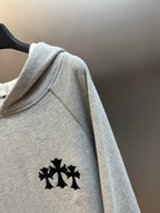 Light gray hooded sweatshirt sleeve with black logo embroidery