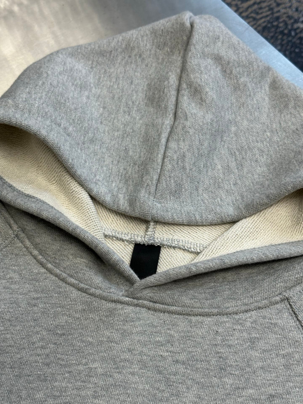 Light gray hooded sweatshirt hood with inner neck label