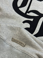 Light gray sweatshirt with black graphic and small leather-look brand patch