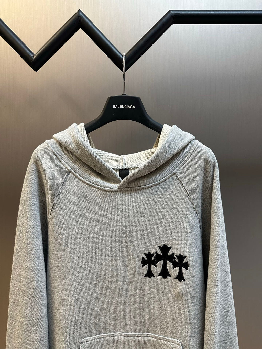 Light gray hooded sweatshirt with black logo print and kangaroo pocket