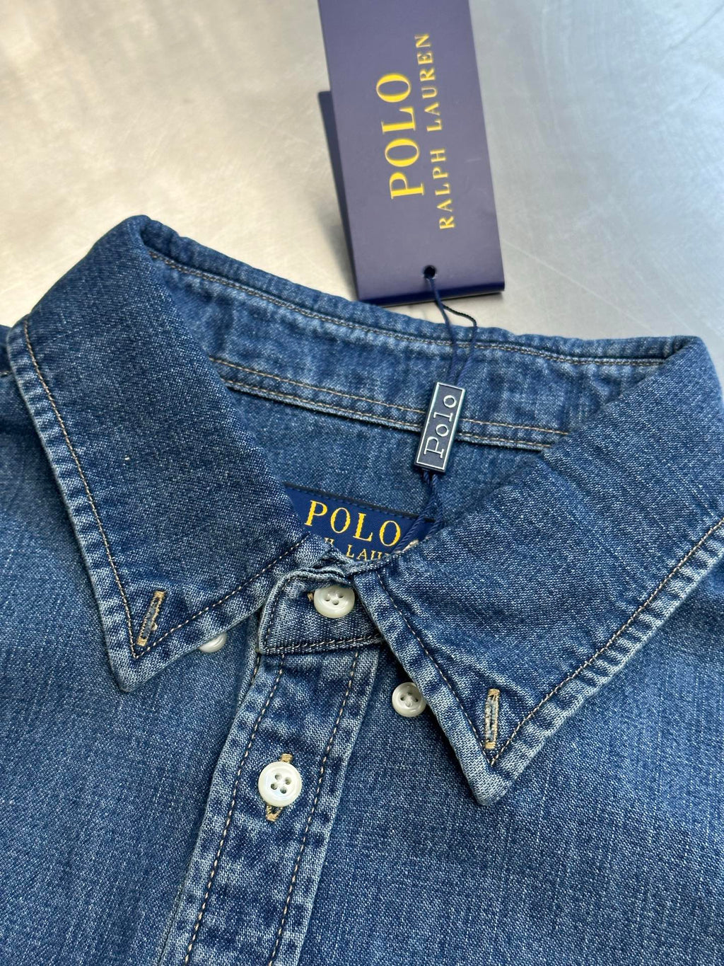 Ralph Lauren blue denim shirt with polo tag, buttoned collar, and chest buttons