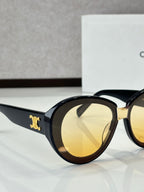 Celine round sunglasses close-up with amber lenses and gold logo on temple