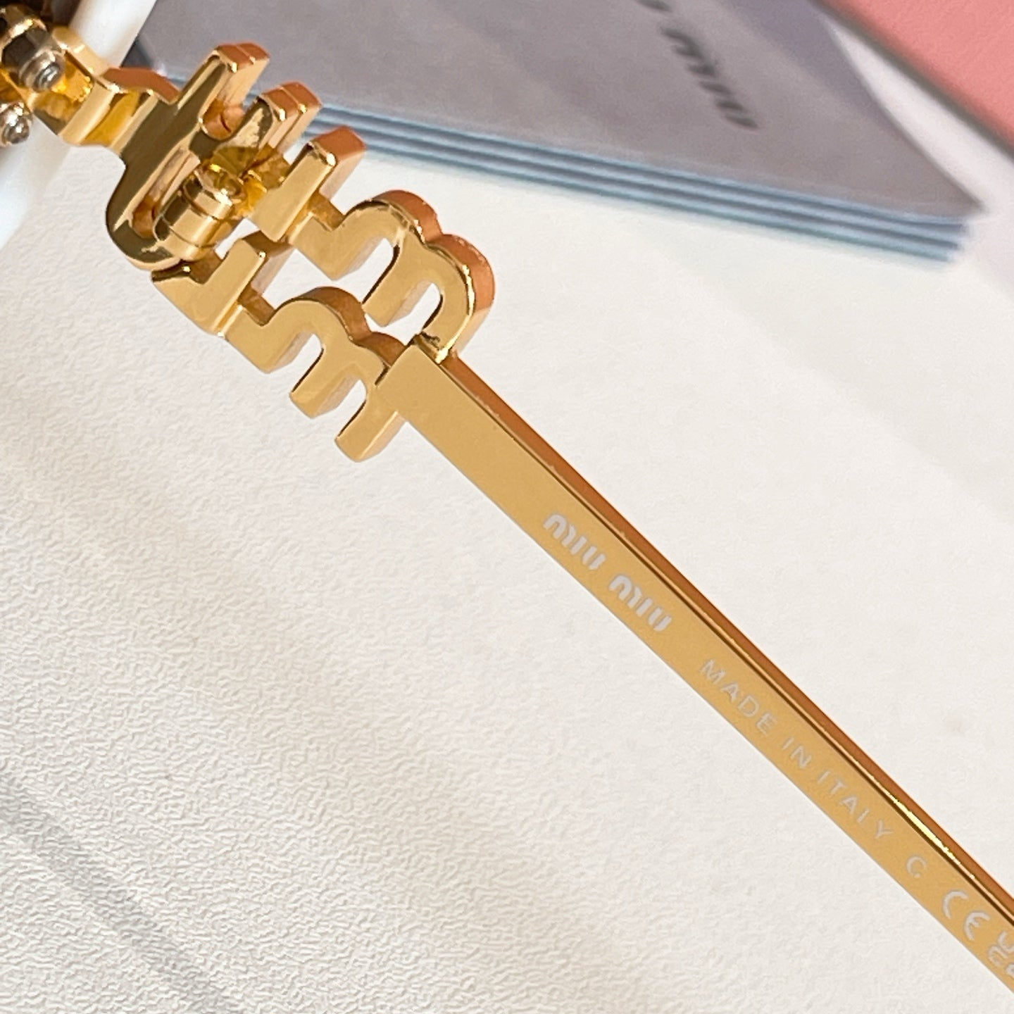 MiuMiu gold metal sunglasses temple with logo print and engraved text