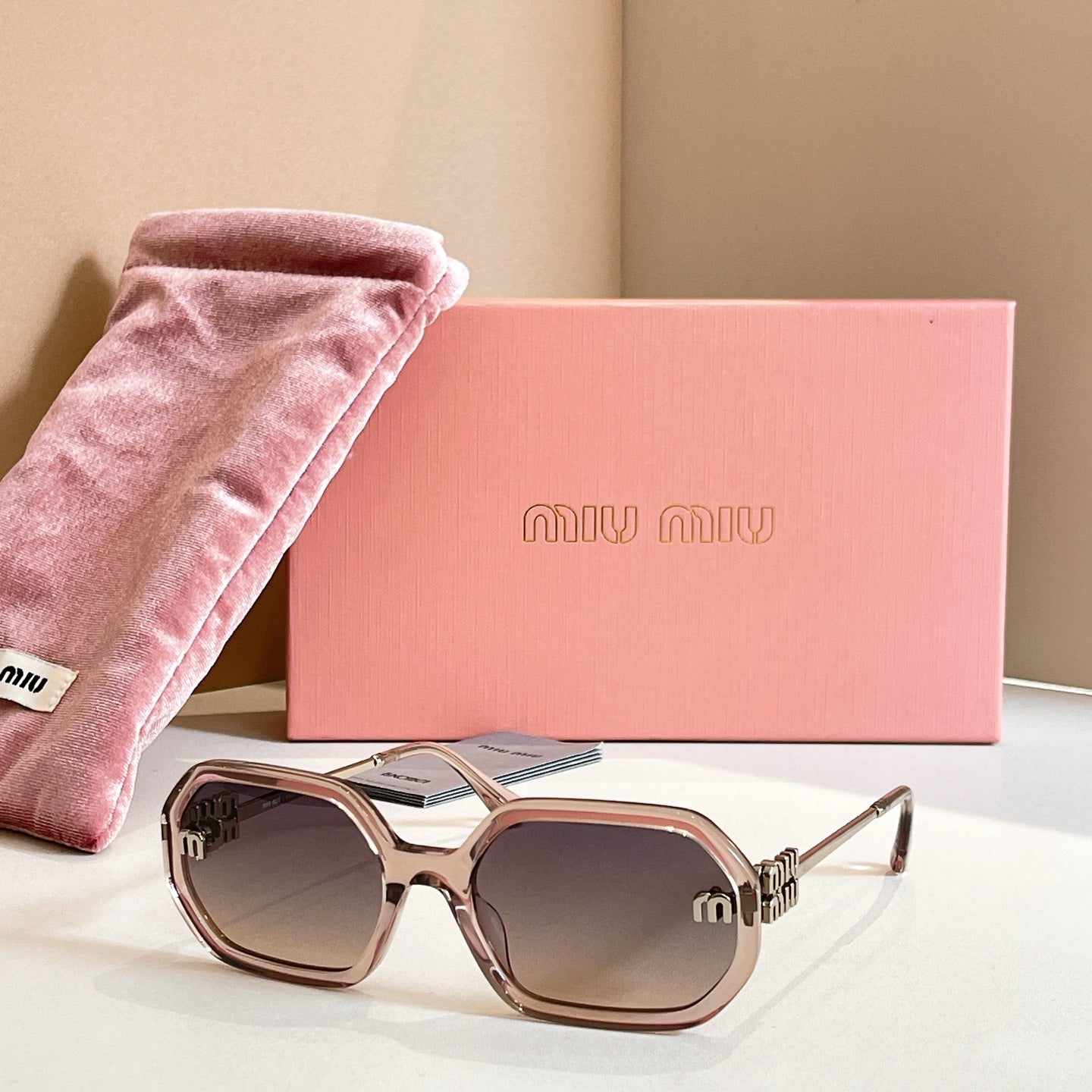 MiuMiu sunglasses with tortoiseshell oversized frames, dark lenses, and gold logo detailing