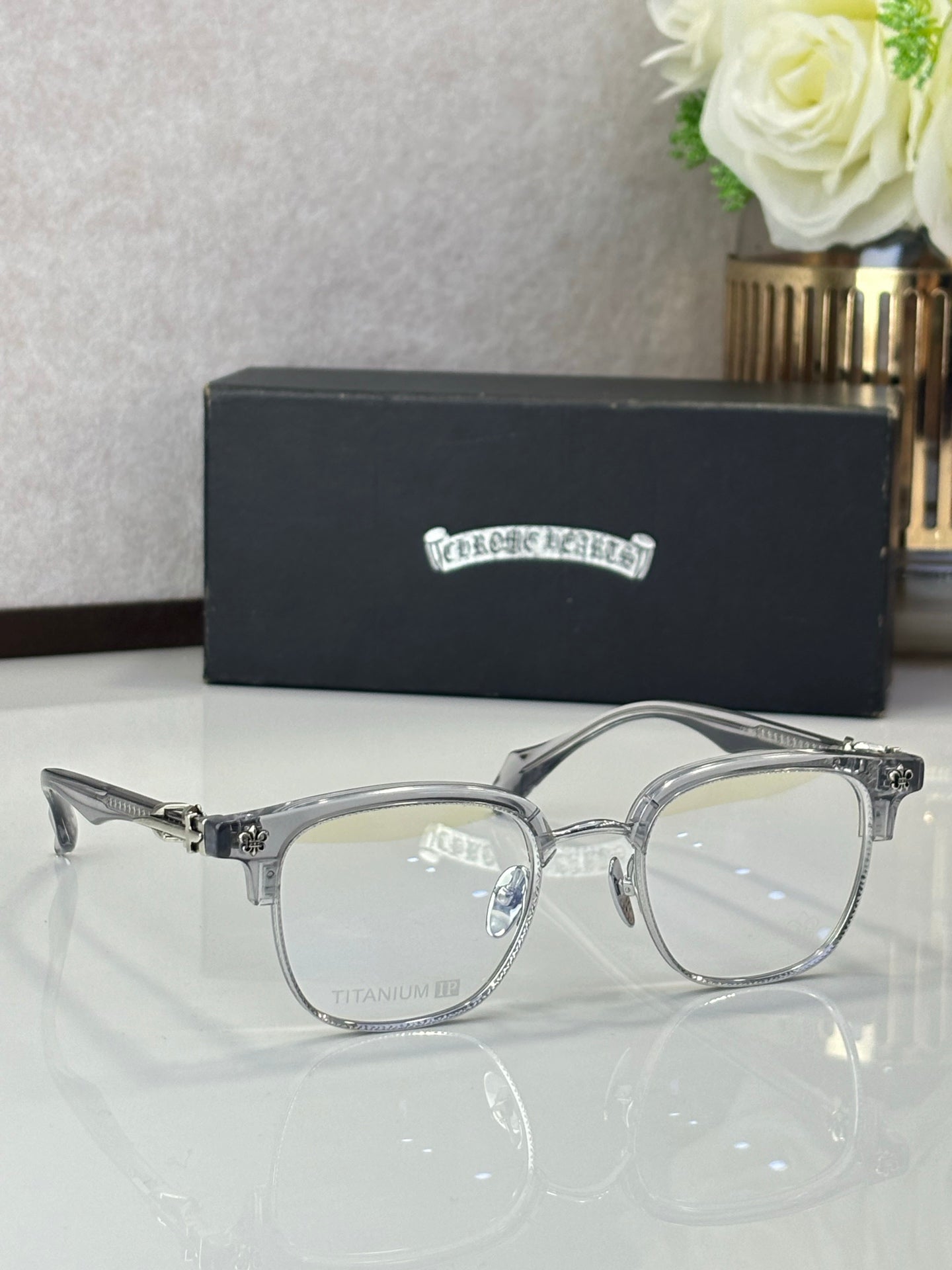 Silver full-rim eyeglasses with clear lenses and ornate temple accents