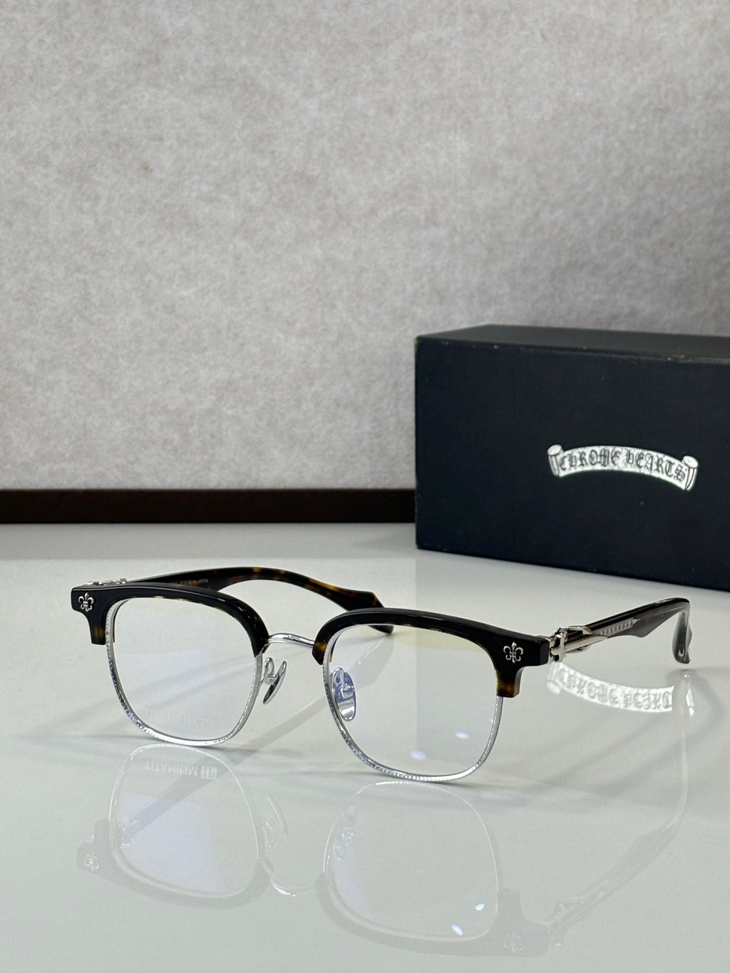 Black and gold full-rim metal eyeglasses with clear lenses, front view