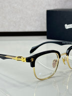 Gold and black metal eyeglasses with clear lenses, round frames