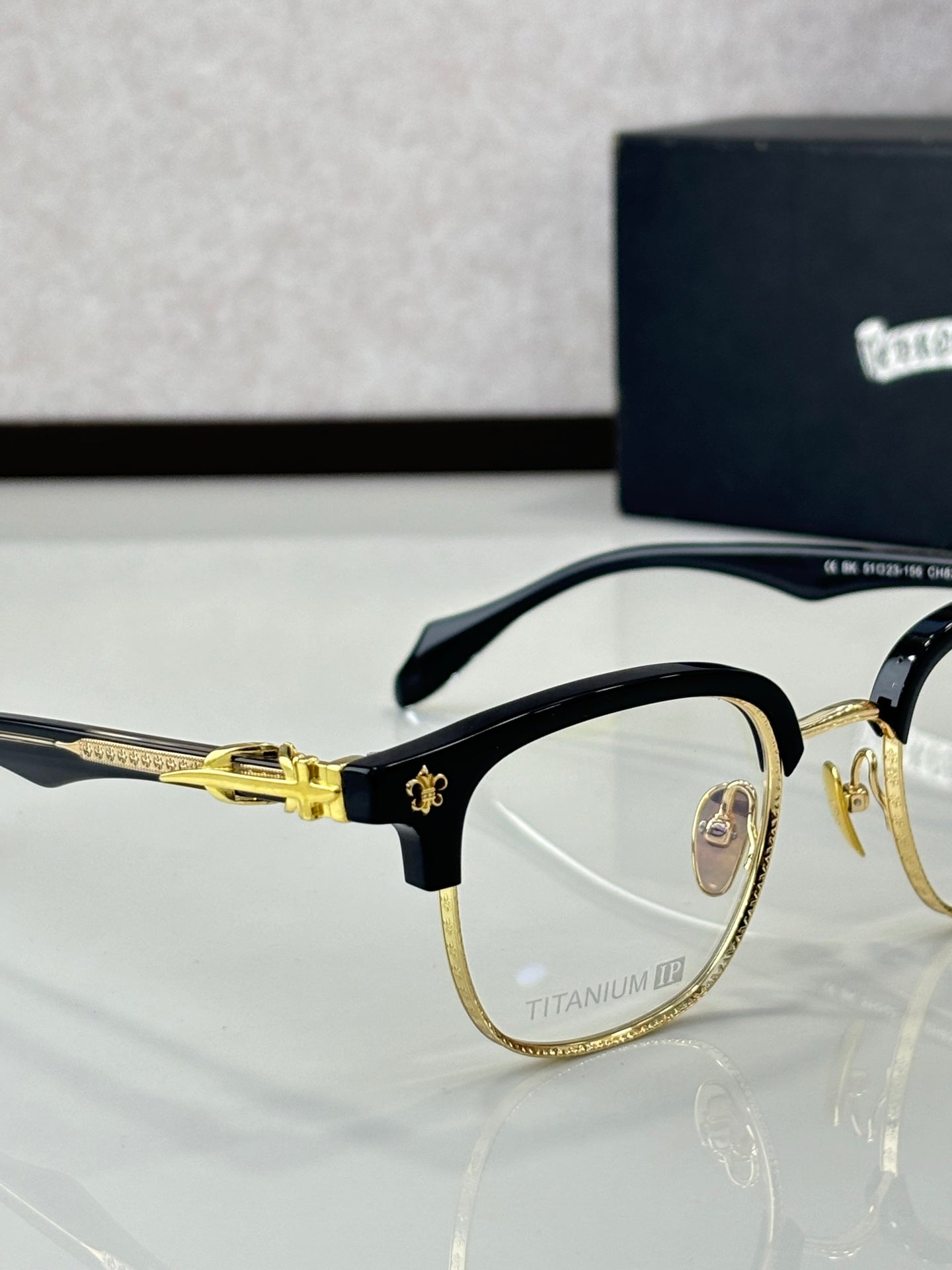 Gold and black metal eyeglasses with clear lenses, round frames