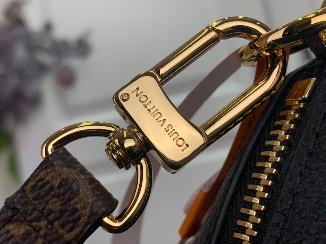 Gold clasp hardware on monogram strap for Louis Vuitton bag