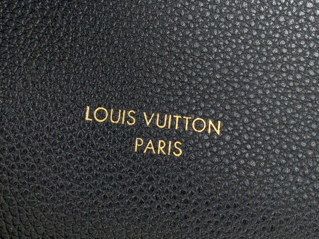 Louis Vuitton Paris embossed text on black textured leather