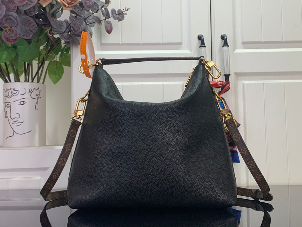 Black leather hobo handbag with gold hardware and monogram side strap