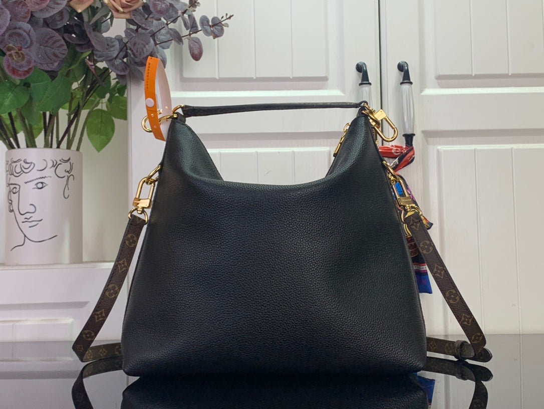Black leather hobo handbag with gold hardware and monogram side strap