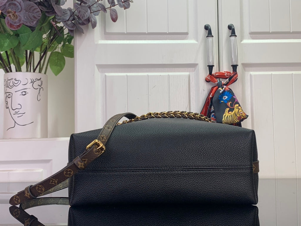Black leather flap bag with gold chain strap and top handle