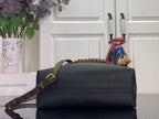 Black leather flap bag with gold chain strap and top handle