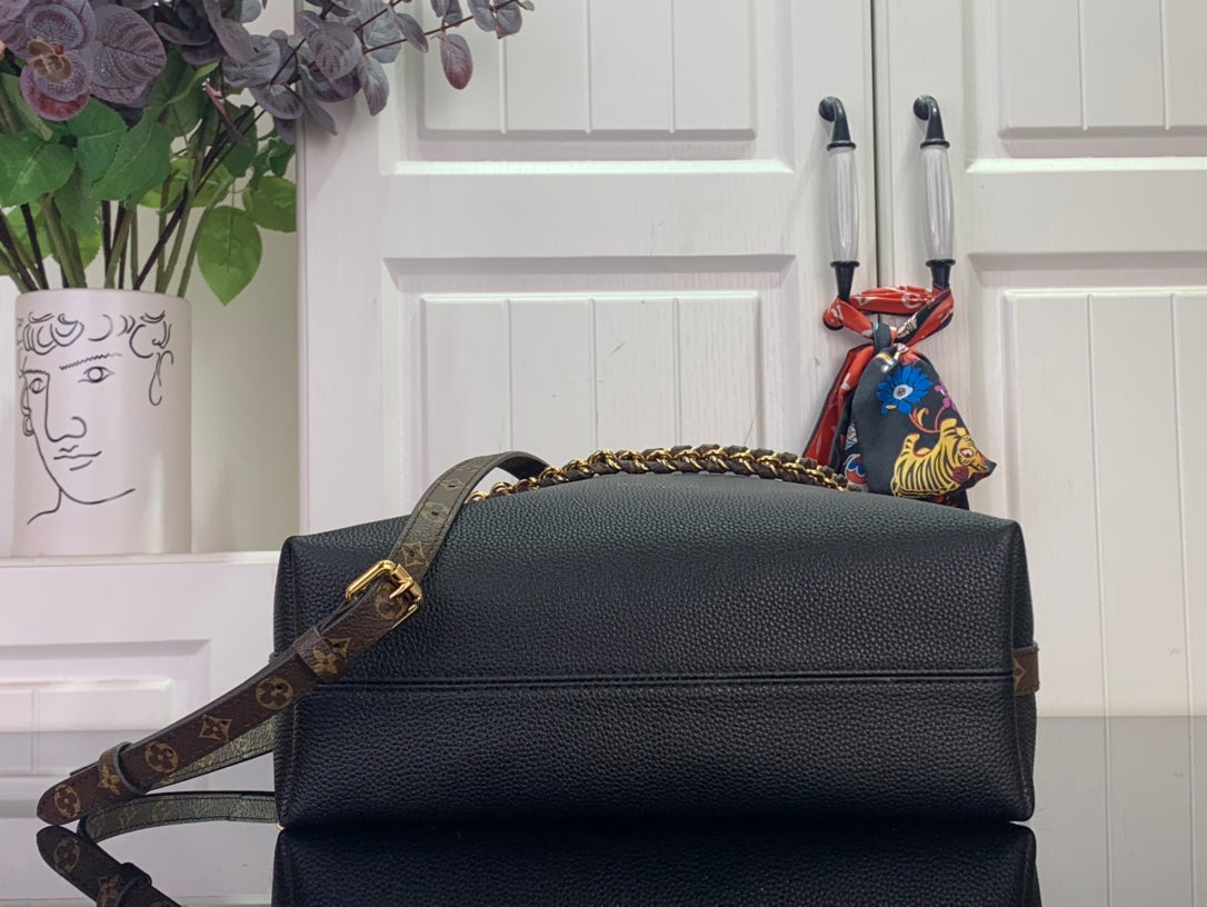 Black leather flap bag with gold chain strap and top handle