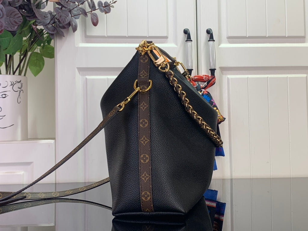 Dark leather hobo bag with monogram canvas trim and gold chain crossbody strap