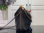 Dark leather hobo bag with monogram canvas trim and gold chain crossbody strap