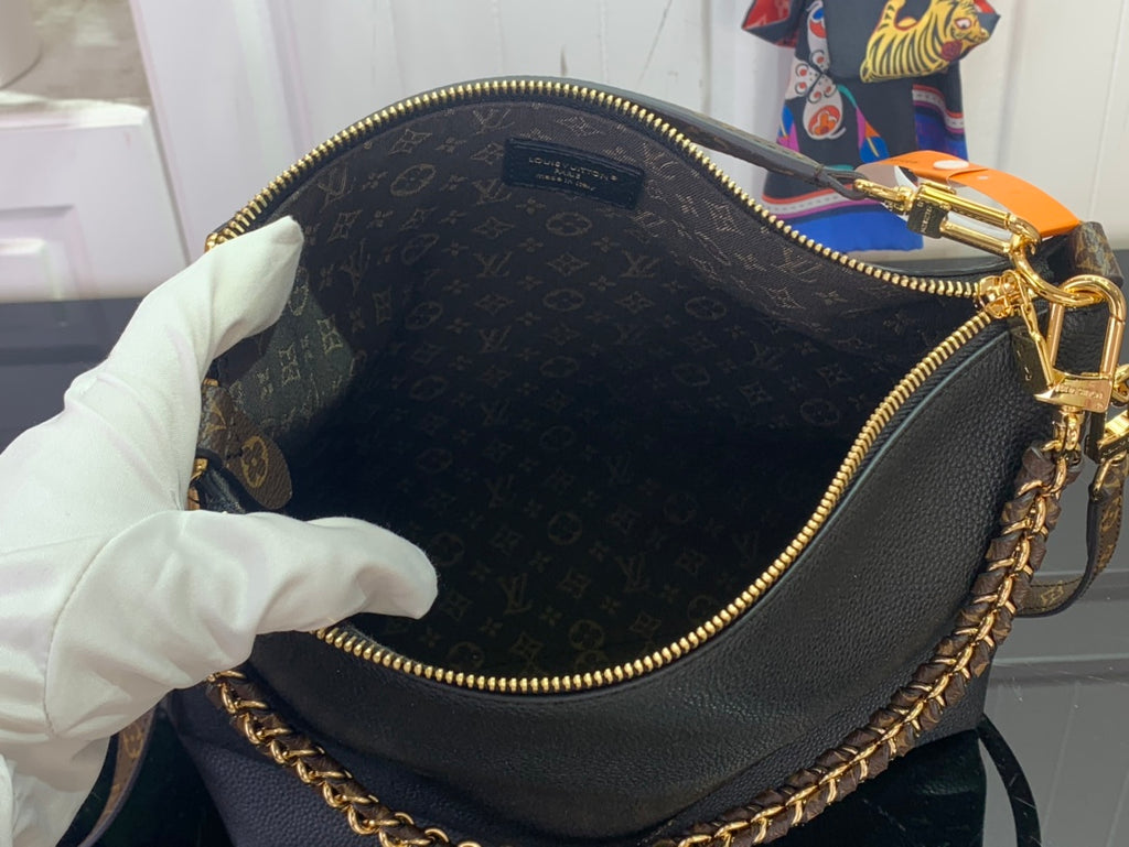 Black leather bag interior with gold zipper trim and chain strap