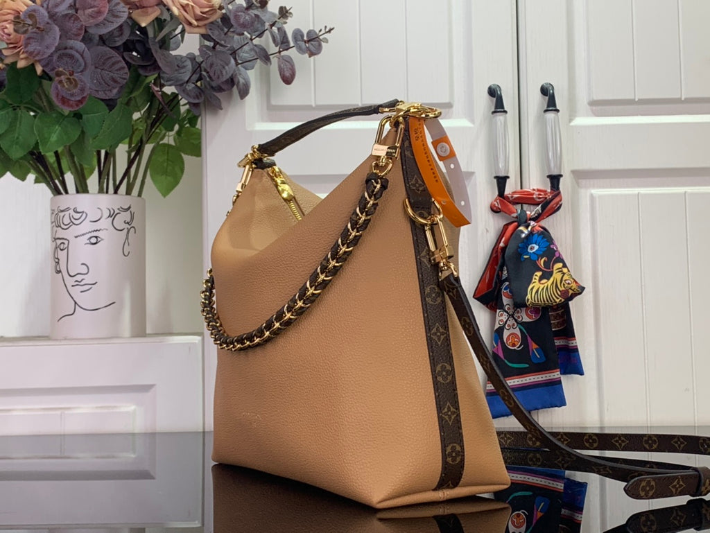 Louis Vuitton hobo shoulder bag with tan leather front, gold chain handle, and patterned strap.