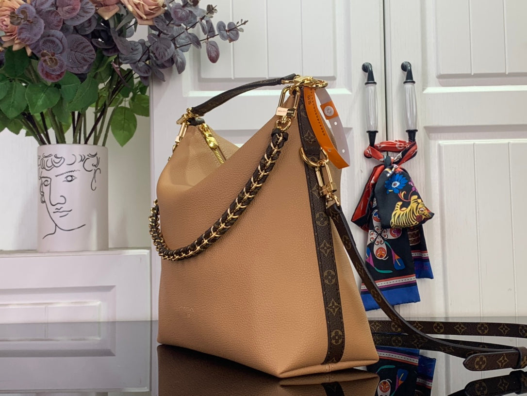 Louis Vuitton hobo shoulder bag with tan leather front, gold chain handle, and patterned strap.