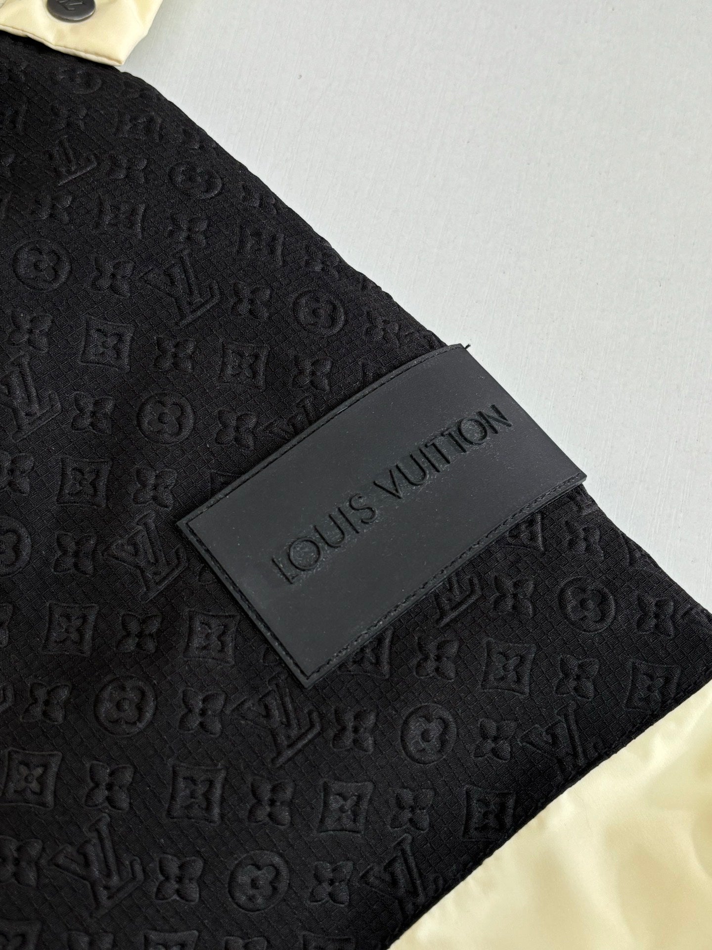 Black monogram-embossed fabric with Louis Vuitton logo patch