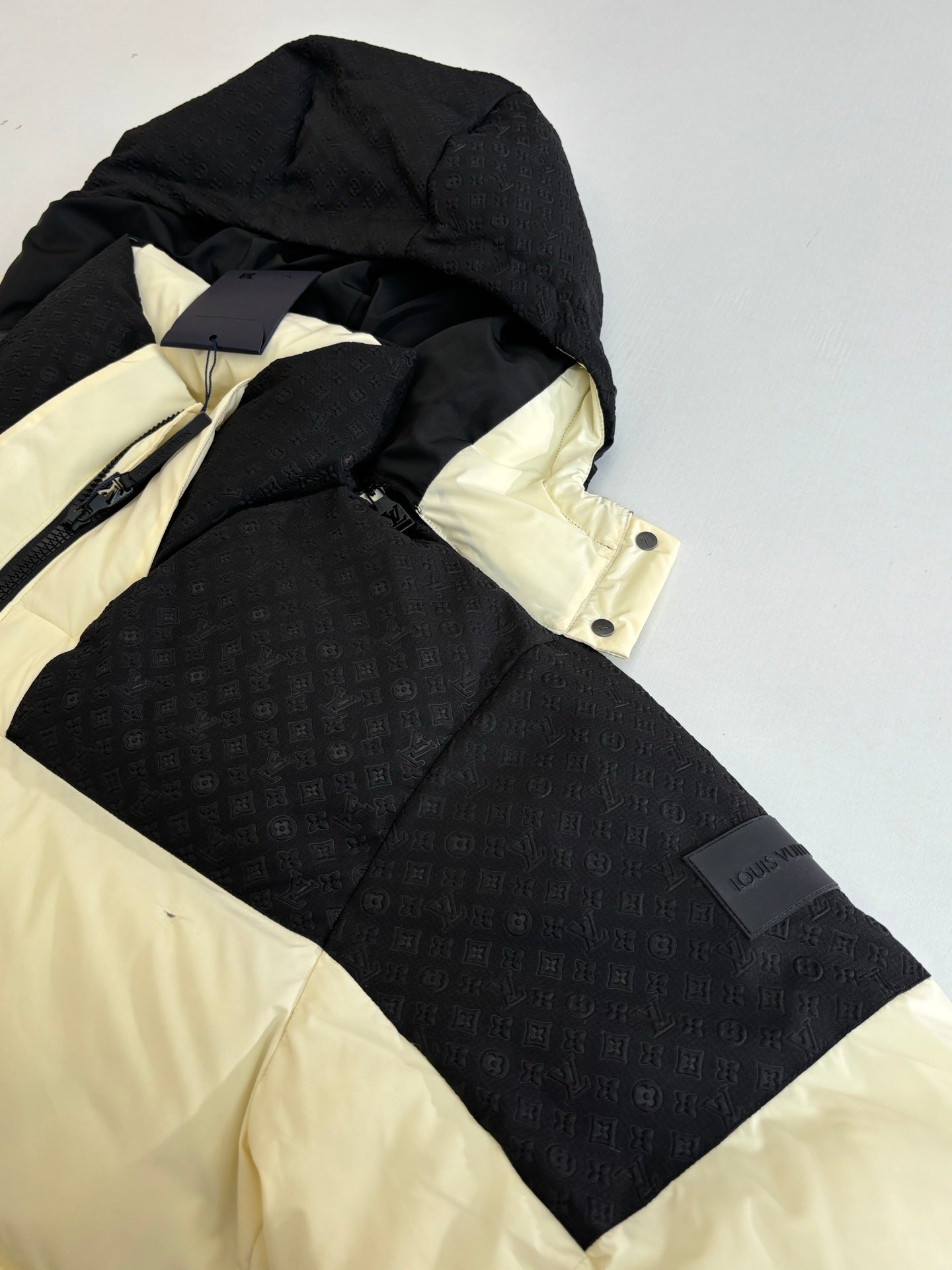 Black puffer jacket with cream hood lining and contrast panels