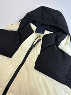 Black and cream hooded puffer jacket close-up with zipper and inner hood