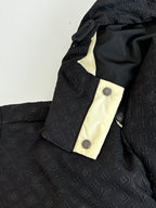 Monogram-style puffer jacket hood and snap placket, black fabric with cream trim
