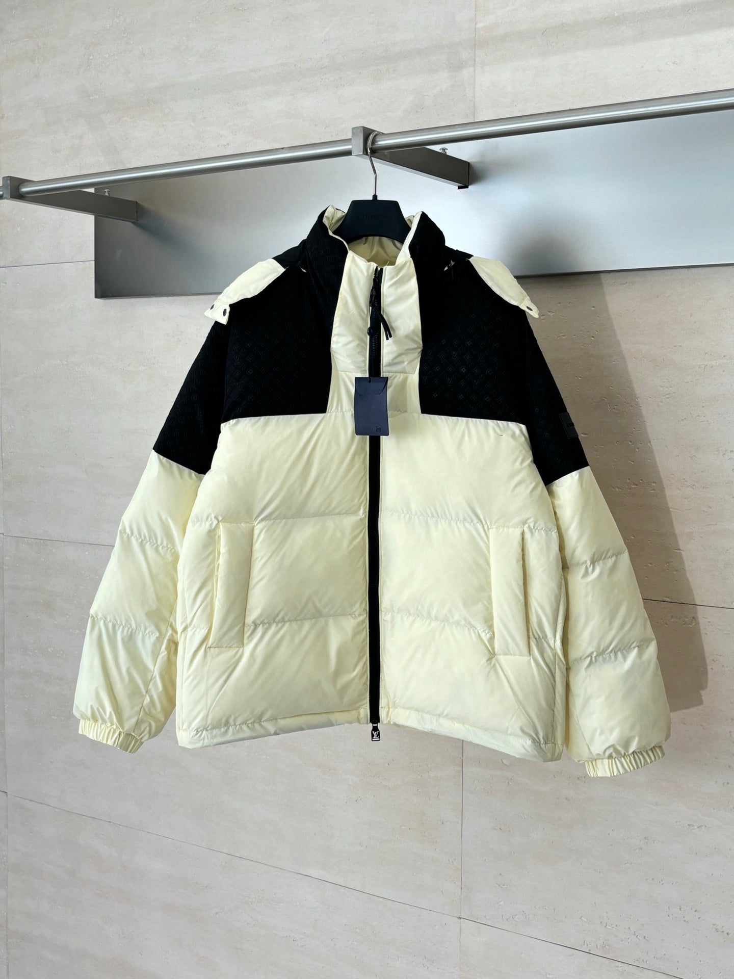 Two-tone puffer jacket with hood, black and cream panels, front zip closure