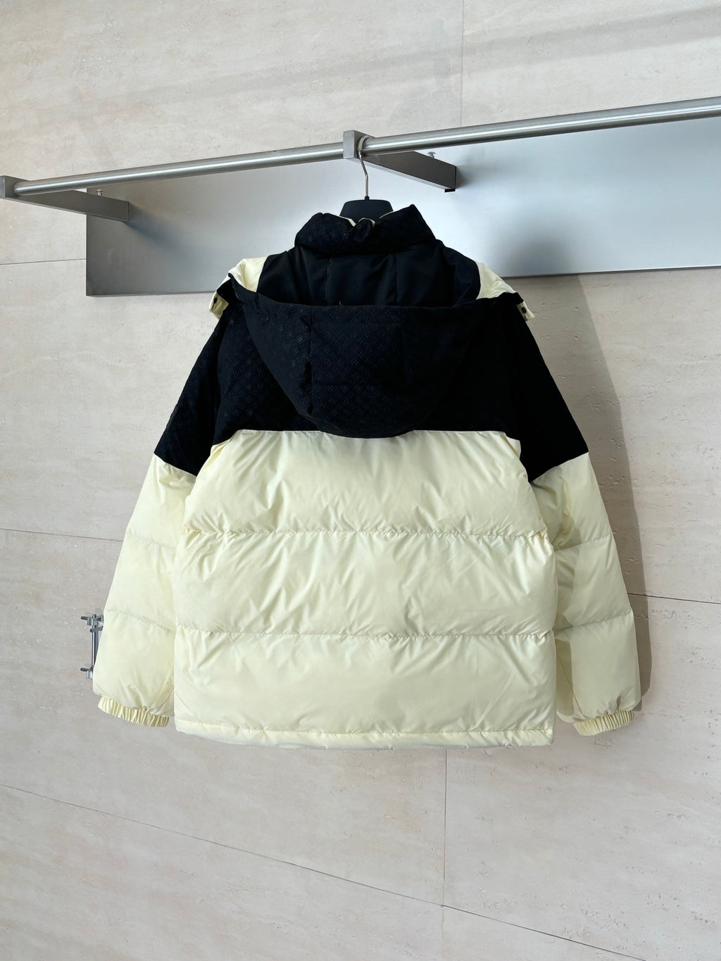 Two-tone hooded puffer jacket with front zip, black top and cream lower panels