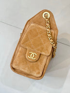Tan suede small handbag with quilted design, gold logo plaque, and chain strap.