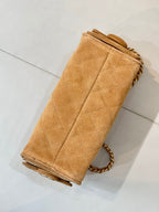 Tan quilted suede handbag with chain strap and folded side seam detail.