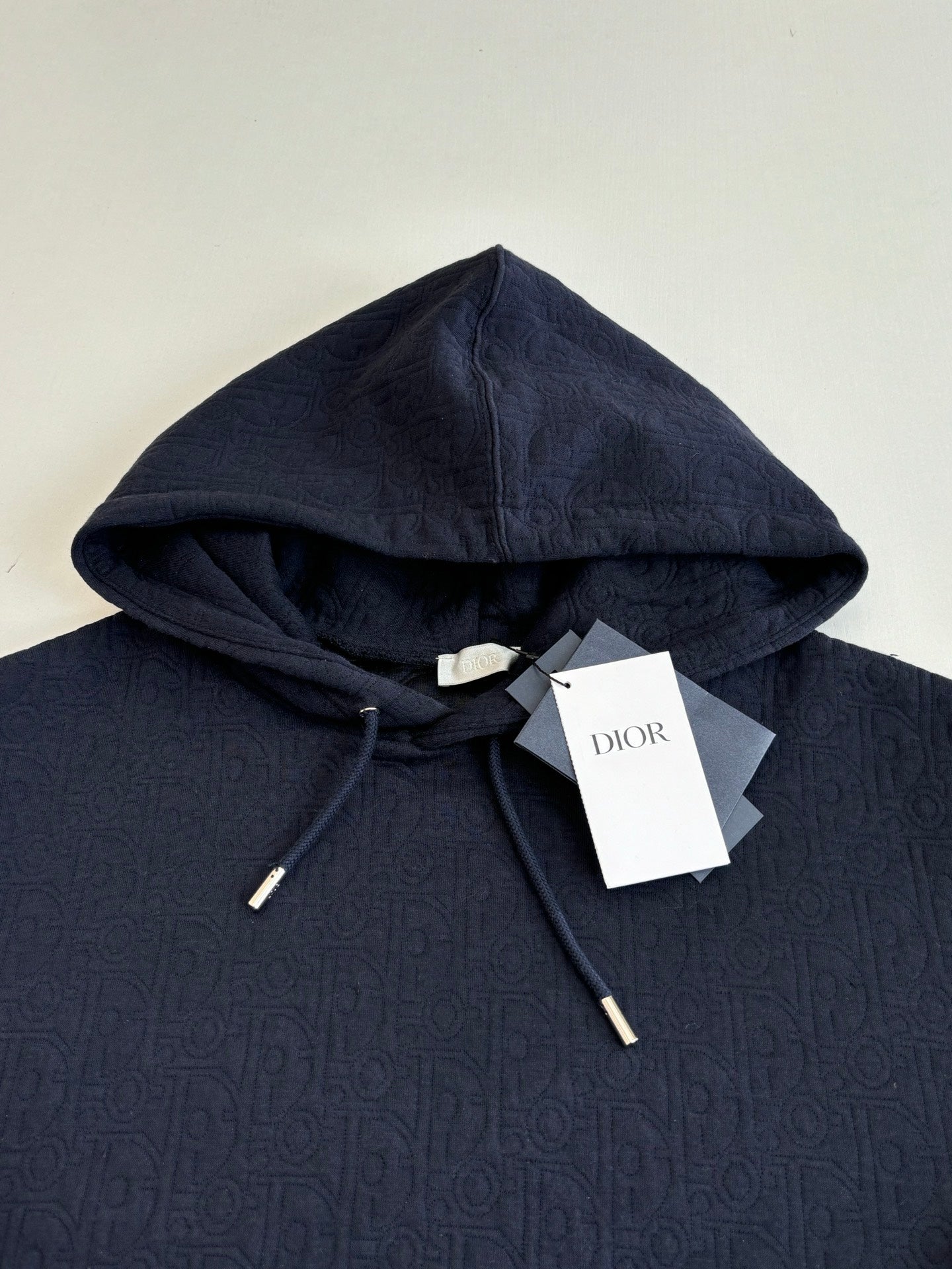 Dior navy pullover hoodie close-up, drawstring hood and front pouch pocket