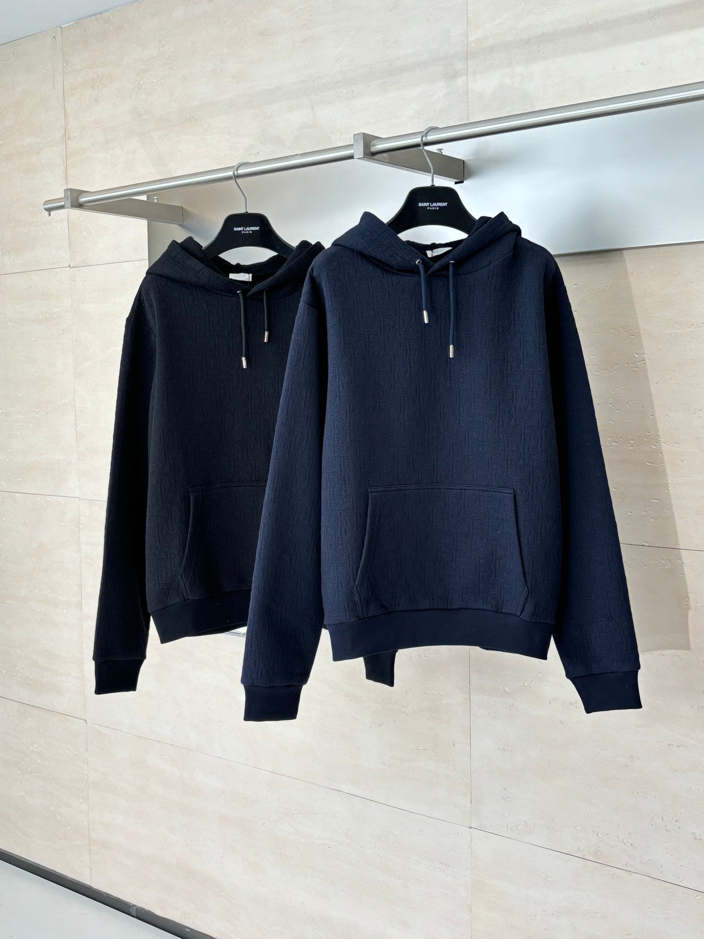 Dior navy pullover hoodies on rack, drawstring hood and front pouch pocket