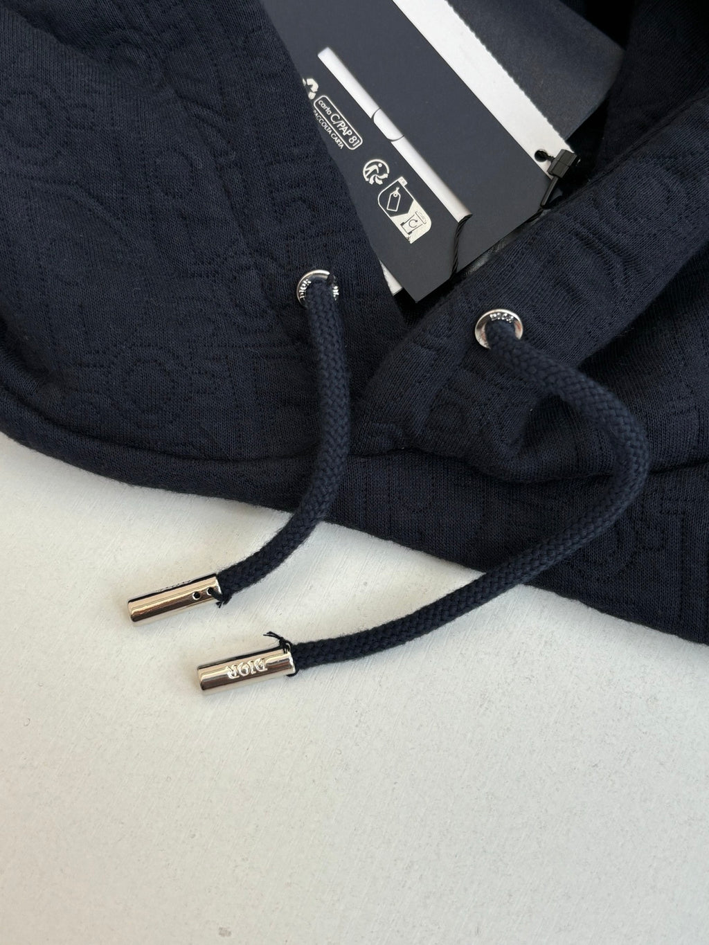 Dior navy hoodie close-up, round drawcord tips and interior label